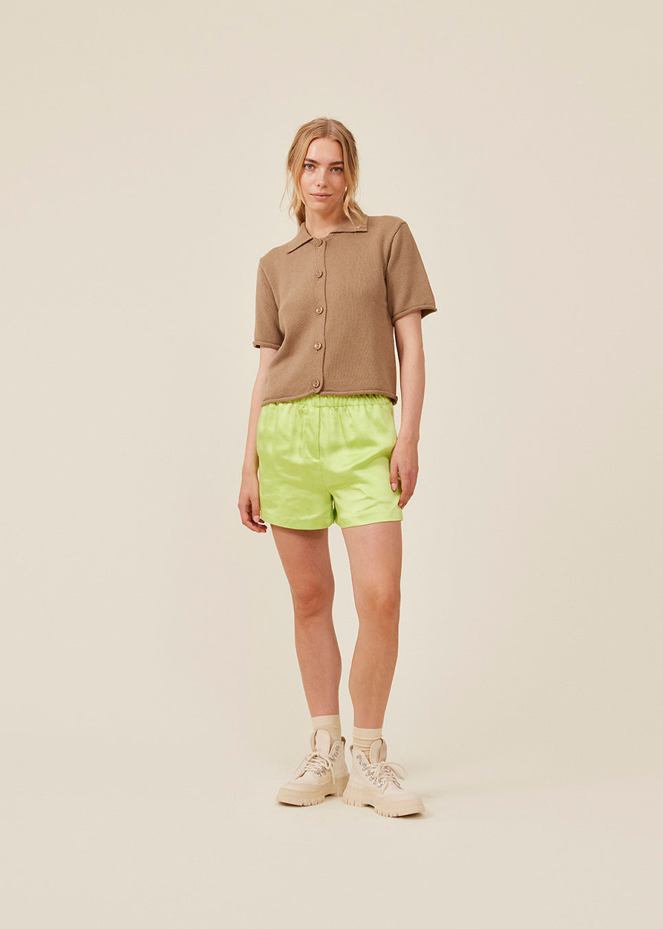 Løse shorts i grøn i satin med elastik i taljen. IolaMD shorts har en mellemhøj taljeog sidelommer. Modellen er 177 cm og har en størrelse S/36 på.