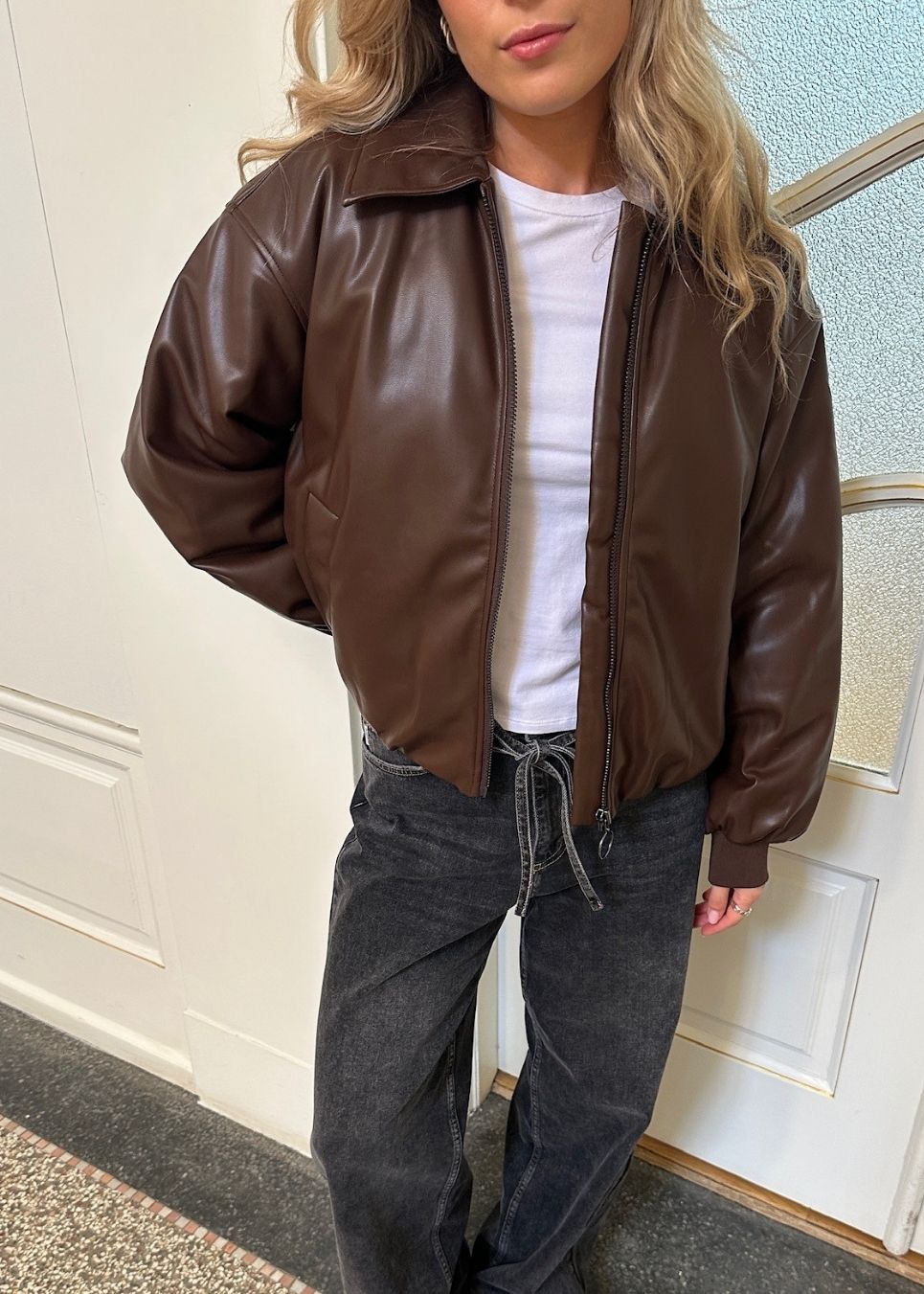 Vatteret brun bomberjakke i PU. Olenamd jacket har en lynlås lukning og krave. Modellen er 175 cm og har en str. S/36 på.
