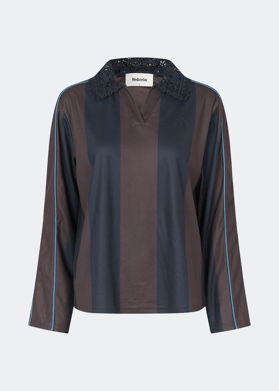 DannieMD Polo er en langærmet polo med en afslappet pasform og brede, vertikale striber. Designet har en dekorativ blondekrave, V-udskæring og kontrastfarvet piping langs ærmerne, som tilfører et sporty element. Style den med jeans eller løse bukser for et afslappet hverdagslook. Modellen er 175 cm høj og bruger størrelse S/36.