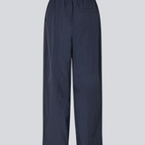 Mørkeblå tracksuit pants i 100% genanvendt nylon. Volmermd pants har piping lang sidesømmen samt cutline detaljer for et sporty look.