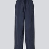 Mørkeblå tracksuit pants i 100% genanvendt nylon. Volmermd pants har piping lang sidesømmen samt cutline detaljer for et sporty look.