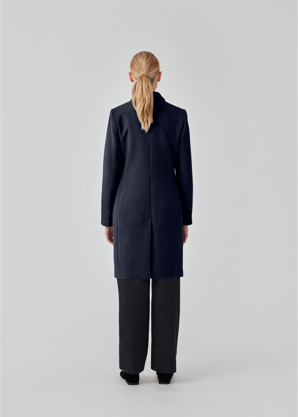 Smuk og klassisk knælang uldfrakke. Odelia coat i farven Navy Sky bliver lukket fortil af fire knapper og er taljeret, hvilket giver et feminint udtryk. På grund af den høje kvalitet af uld, vil den være det oplagte valg til både efterår og de milde vintre.
