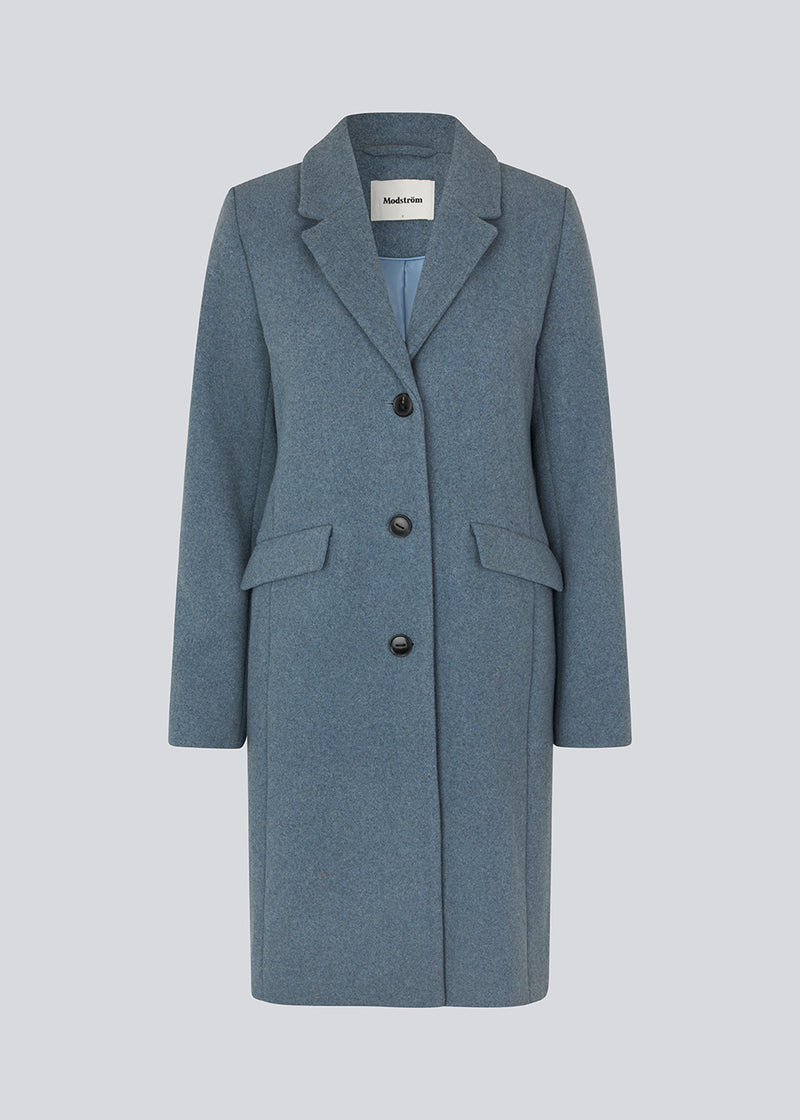 Smuk knælang uldfrakke. Pamela coat, i farven Blue Moon, bliver knappet fortil af 3 store knapper og er taljeret, som giver et feminint udtryk. På grund af den høje kvalitet af uld, vil den være det oplagte valg at bruge til både efterår og de milde vintre. Modellen er 176 cm og har en størrelse S/36 på