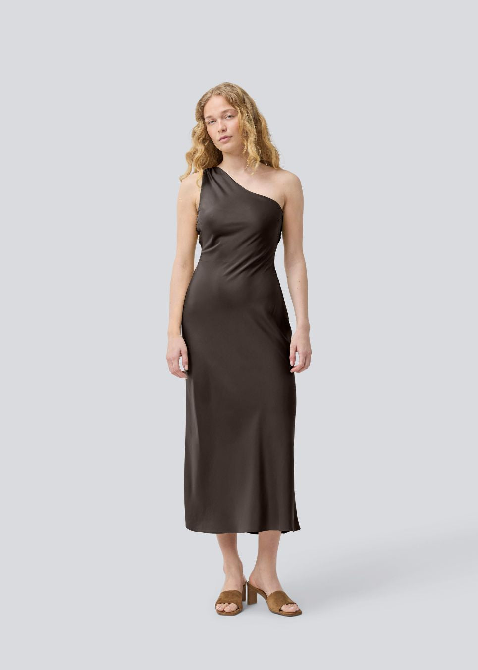 Vores populære Narcissamd dress er nu endelig kommet i en flot mørkebrun.
Mørkebrun lang one shoulder kjole i satin. NarcissaMD dress er en maxi dress med en åben ryg med smukke detaljer og en usynlig lynlås i siden.