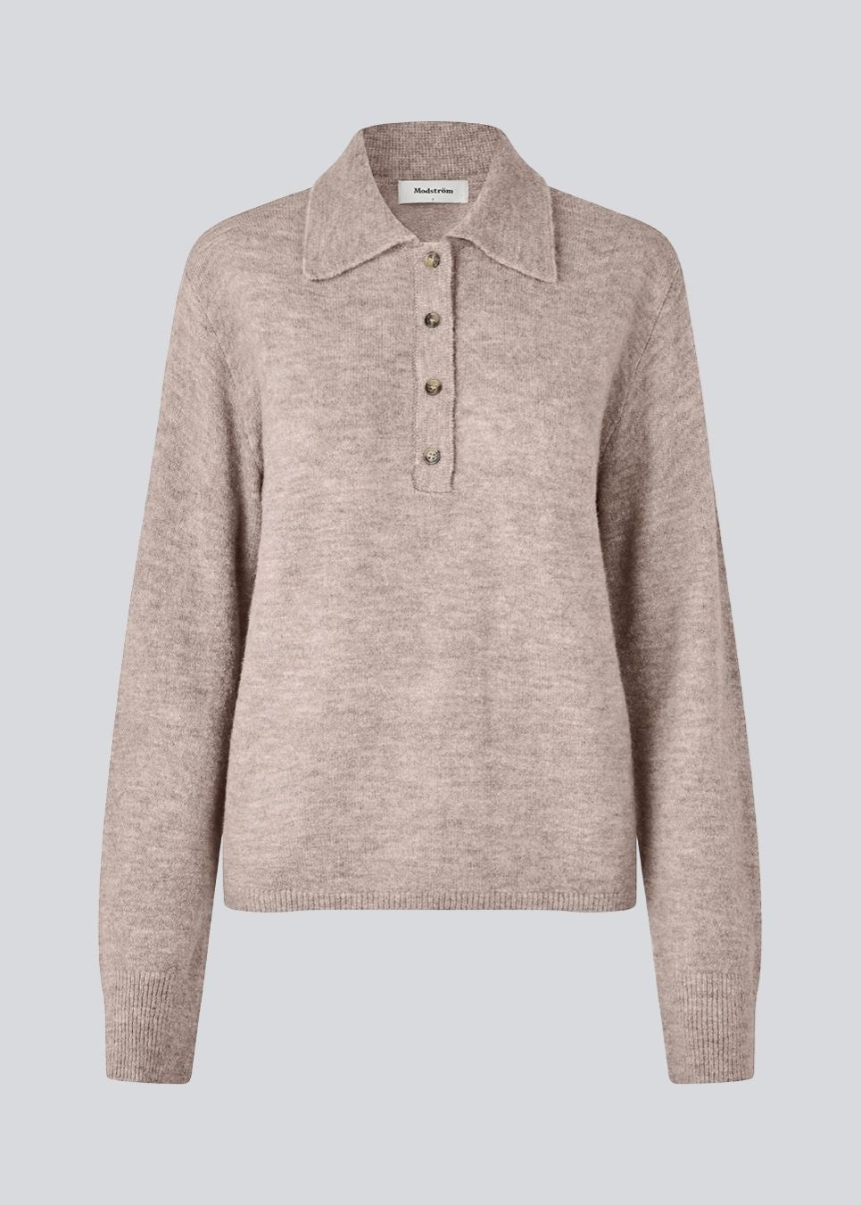Strikket polo med lange ærmer. Treemd polo har en stolpelukning og 4 knapper.