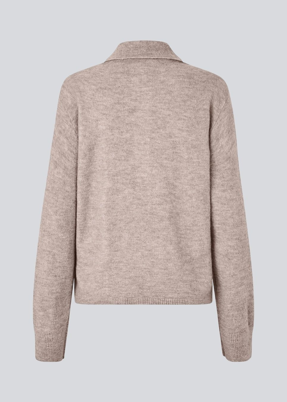 Strikket polo med lange ærmer. Treemd polo har en stolpelukning og 4 knapper.