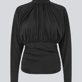 Elegant sort bluse med høj hals og lange ærmer. Blusen er designet med fine rynkedetaljer ved brystet og taljen, som skaber en flatterende silhuet. Den har en diskret knaplukning bagpå i nakken, som giver et sofistikeret og feminint udtryk. Det strækbare stof sikrer en behagelig pasform, mens det draperede snit tilføjer ekstra elegance. Perfekt til både hverdagsbrug og festlige lejligheder.