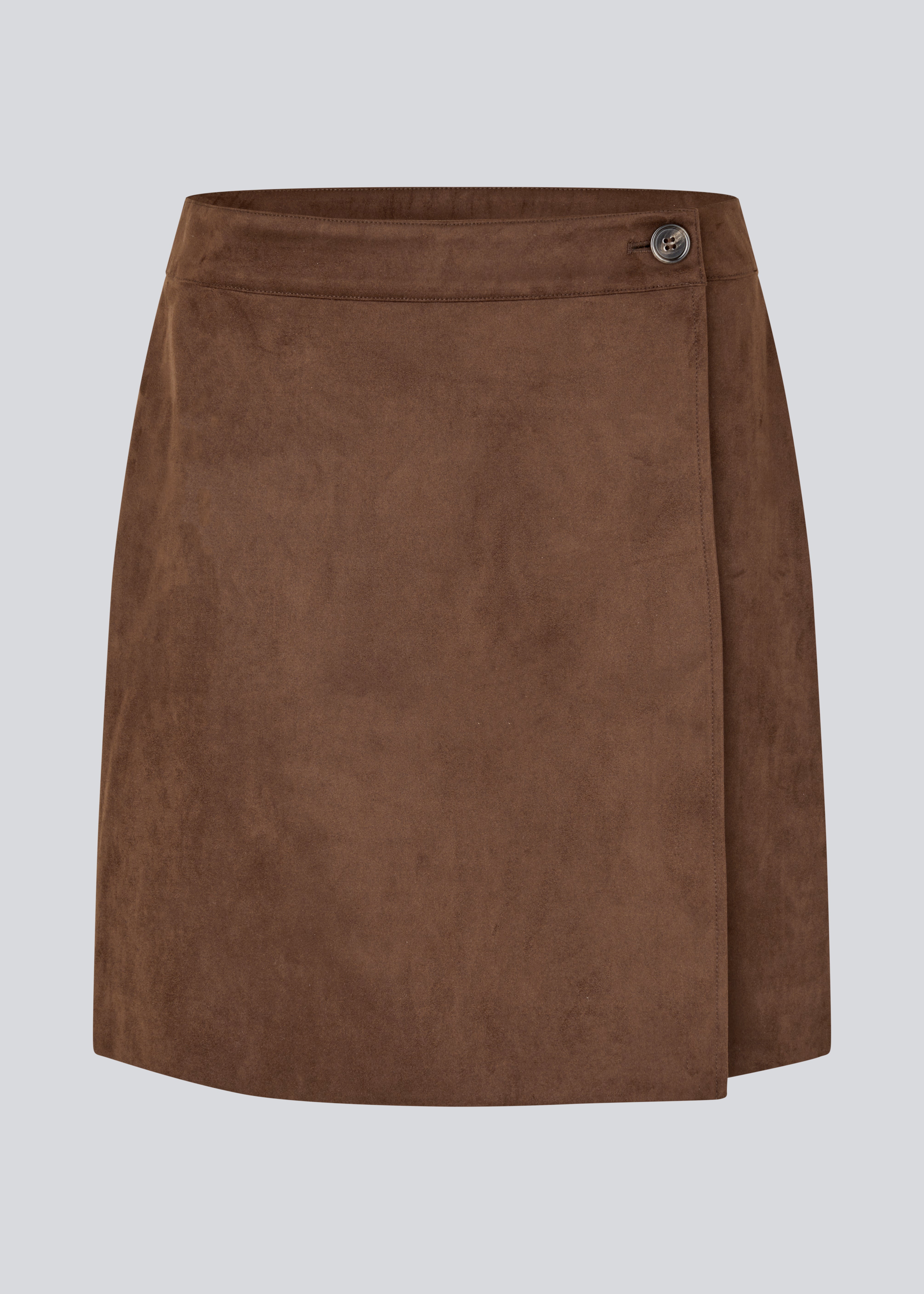 Kort brun nederdel i ruskindslook med elegant slåom design. Nederdelen lukkes med en dekorativ knap i siden, som tilføjer et stilrent og feminint touch. Det bløde materiale giver en behagelig pasform, og det enkle snit gør den nem at style til både hverdag og mere formelle lejligheder.