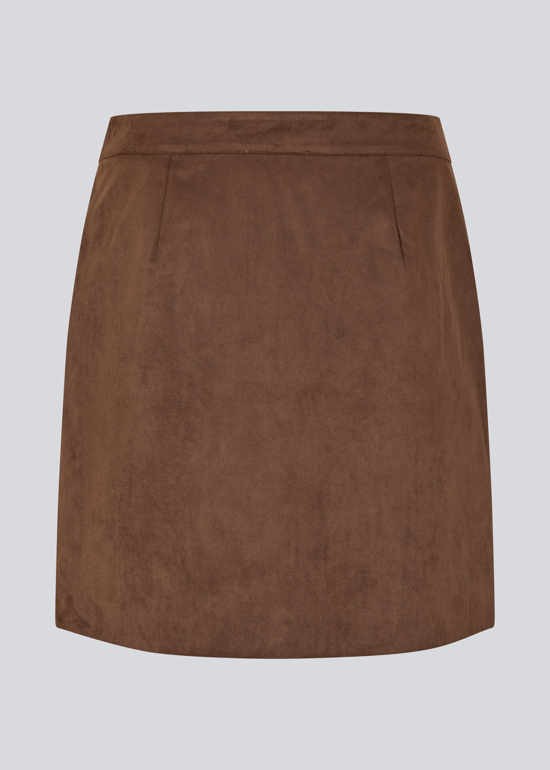 Kort brun nederdel i ruskindslook med elegant slåom design. Nederdelen lukkes med en dekorativ knap i siden, som tilføjer et stilrent og feminint touch. Det bløde materiale giver en behagelig pasform, og det enkle snit gør den nem at style til både hverdag og mere formelle lejligheder.