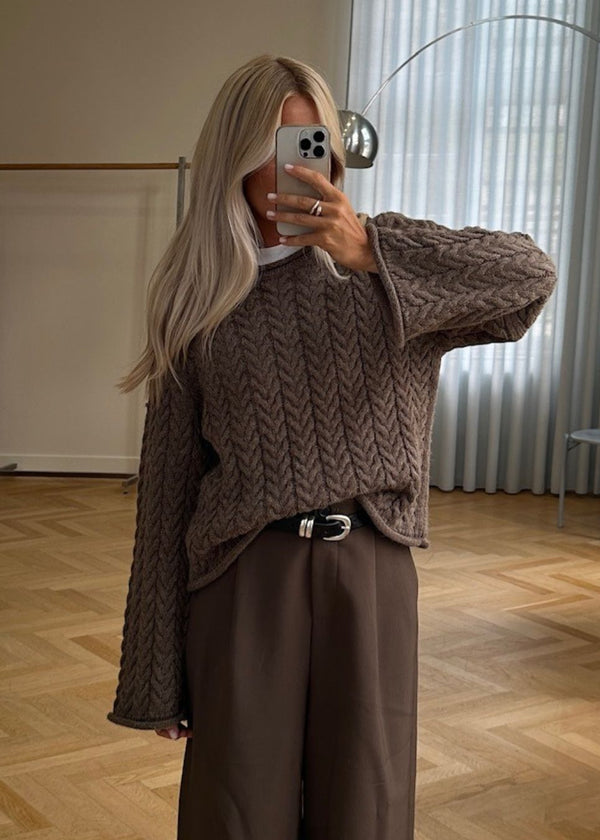 Løs strik med brede ærmer i kabel strik. KurtisMD v-neck har en rund halsudskæring og rullede detaljer på ærmerne og halsen.