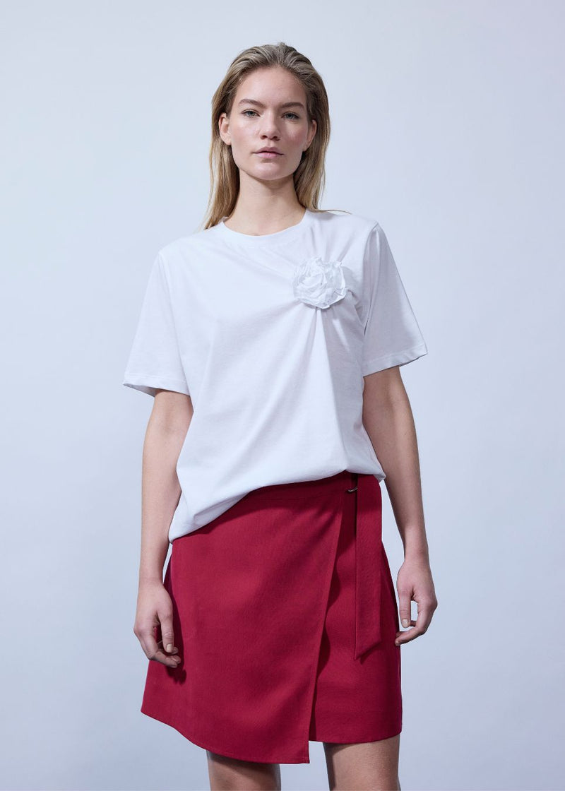 Kortærmet t-shirt med rose detalje på brystet. &nbsp;Priyamd t-shirt har en løs pasform og er fremstillet i 100% økologisk bomuld. Modellen er 175 cm og har en str S/36 &nbsp;på.

