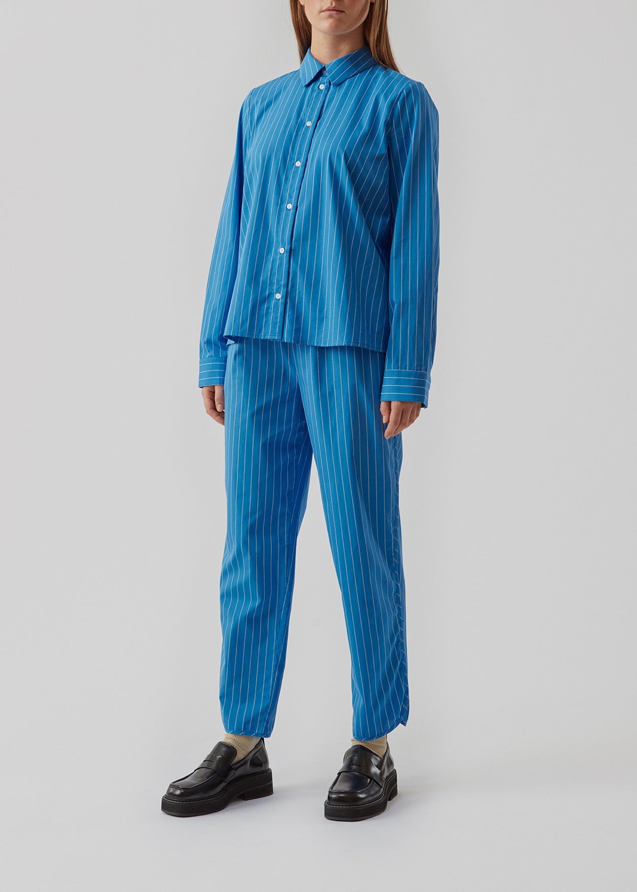 Percy shirt er en pyjamas-inspireret bomuldsskjorte. Skjorten har en afslappet pasform med brede ærmer. Bær skjorten med de matchende bukser for et cool look. Modellen er 173 cm og har en størrelse S/36 på