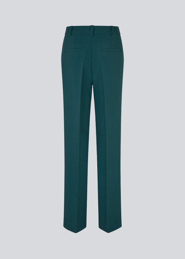 Mørkegrøn gale pants har et klassisk design. Buksen har lige, vide ben med pressefolder som skaber et elegant udtryk. Bukserne forlænges med 0,5 cm for hver størrelse.