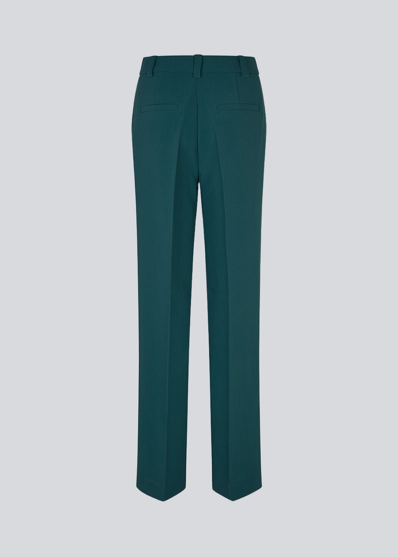 Mørkegrøn gale pants har et klassisk design. Buksen har lige, vide ben med pressefolder som skaber et elegant udtryk. Bukserne forlænges med 0,5 cm for hver størrelse.