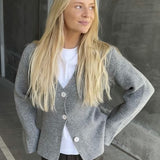 Glatstrikket cardigan i grå med v-udskæring i 100% uld. KlaytonMD cardigan er figursyet, har lange brede ærmer og knapper foran.