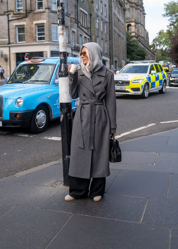 Klassisk, dobbeltradet grå uldfrakke med krave og revers. ShayMD coat har bredt taljebælte, skulderstropper, brede manchetter og stormflap. Med for og slids bagpå.