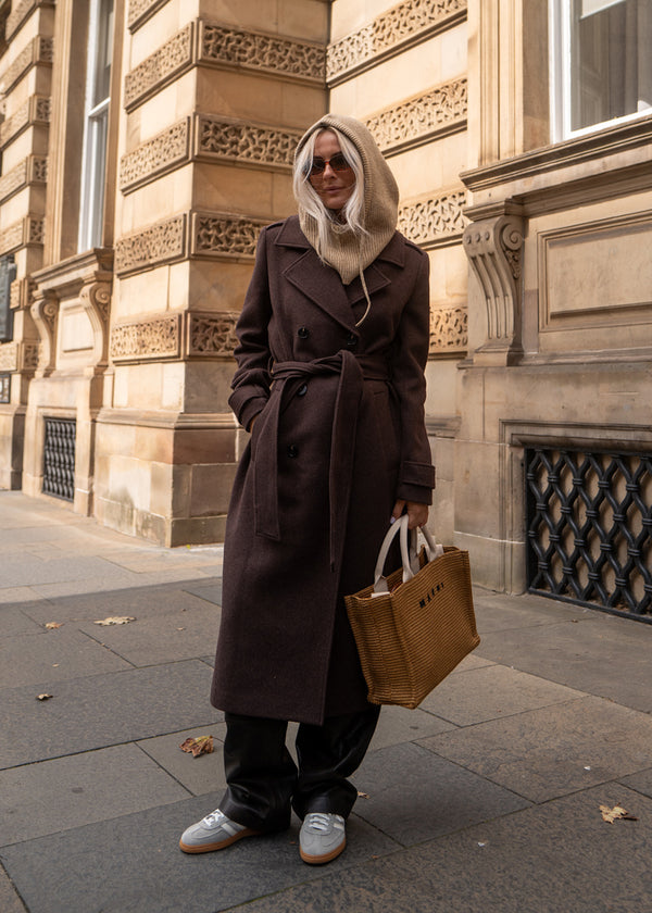 Klassisk, brun dobbeltradet uldfrakke med krave og revers. ShayMD coat, i farven Dark Coffee, har bredt taljebælte, skulderstropper, brede manchetter og stormflap. Med for og slids bagpå.&nbsp;