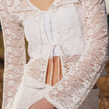 Figursyet top i hvid stretchy blonde med ærmer, der bliver bredere forneden. TildeMD lace top har en dyb V-udskæring og to bindebånd foran.