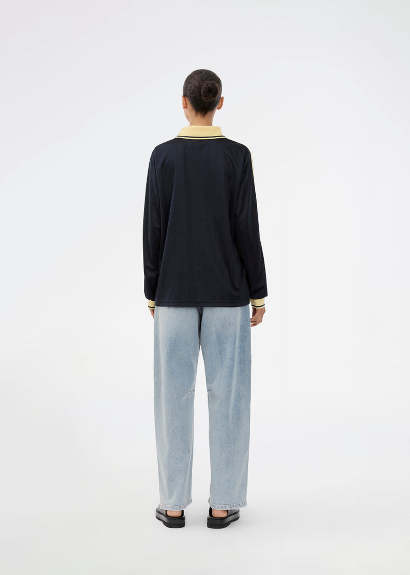 Fodbold jersey i mørkeblå med gule detaljer lavet i samarbejde med Brøndbys kvindehold. 1971 Polo har en løs pasform med stolpelukning og krave, samt lange ærmer med ribkant. Desuden har poloen Brøndby Womens og Modström logo på brystet.