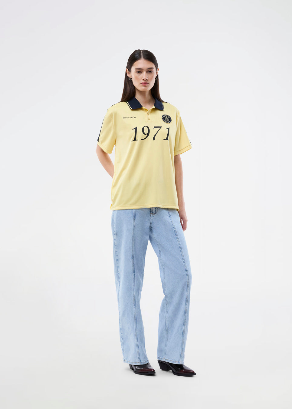 Fodbold jersey i gul med mørkeblå detaljer lavet i samarbejde med Brøndbys kvindehold. 1971 Polo har en løs pasform med stolpelukning, krave samt korte ærmer. Desuden har poloen Brøndby og Modström logo på brystet.

Poloen er unisex og skabt til både fans, fodboldelskere og dig der bare vil have et sporty look.