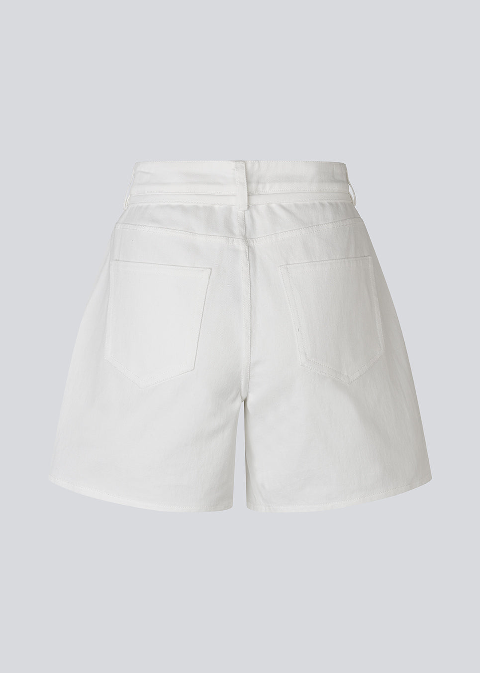 Stilrene shorts i hvid bomuldsdenim. AggiMD Solid Shorts er lange og har klassiske detaljer som lommer, bæltestropper, knap- og lynlåslukning i gylpen samt snørrebælte i taljen. Et moderne og afslappet valg til sommerens outfits.