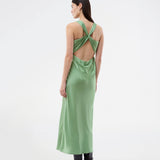 Lang kjole i glansfuld satin og åben ryg. AijaMD Dress har et feminint design med smukt fald i skørtet, figursyet talje, drapering ved brystet og en elegant kryds-ryg. Fremstillet i 100% genanvendt polyester, perfekt til både aften- og festlooks.
 