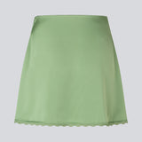 Mininederdel i glansfuld satin. AijaMD Skirt har feminine detaljer som blondekant i enden og et figursyet snit, der går let ud i bunden. Nederdelen har en diskret lynlåslukning i siden og er fremstillet i 100% genanvendt polyester.