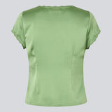 Feminin kortærmet top i glansfuld satin. AijaMD Top har fine detaljer som blondekanter, V-udskæring, let puf under brystet og sløjfedetalje. Fremstillet i 100% genanvendt polyester, perfekt til både elegante og afslappede looks.