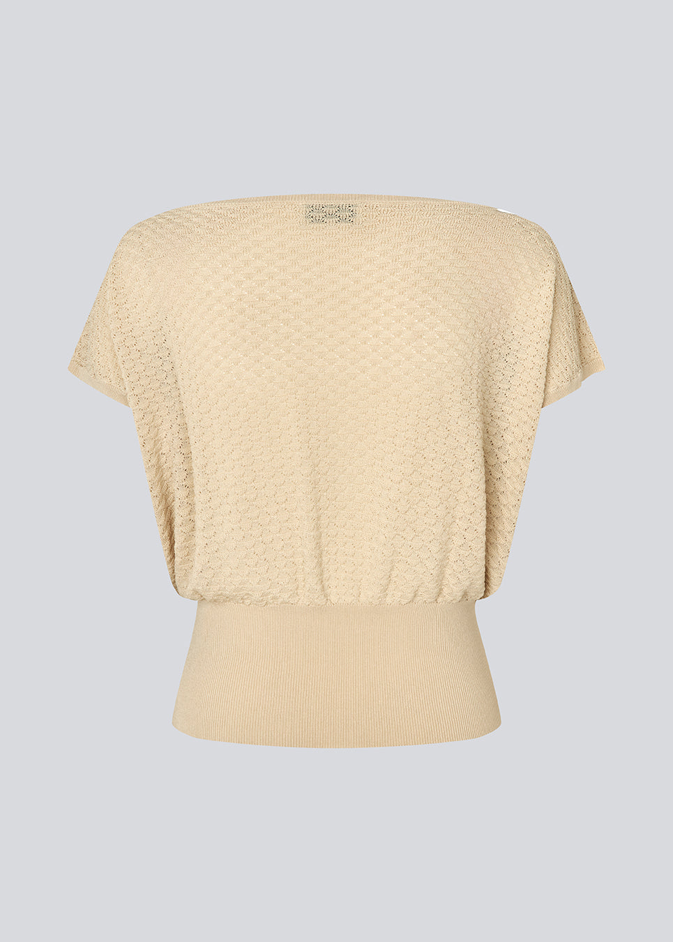 Feminin top med markeret talje. AjaMD Top har korte ærmer og båd-halsudskæring. Den er designet i elastisk stof med hulmønster og ribkanter, der giver et moderne og feminint look.