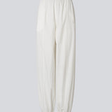 Hvide ballonbukser i 100% økologisk bomuld. AkselMD Pants er designet med sidelommer og elastik i taljen samt ved anklerne, hvilket skaber en ballon-effekt. Et par chic og stilrene bukser, perfekte til både hverdag og mere dressed-up looks.