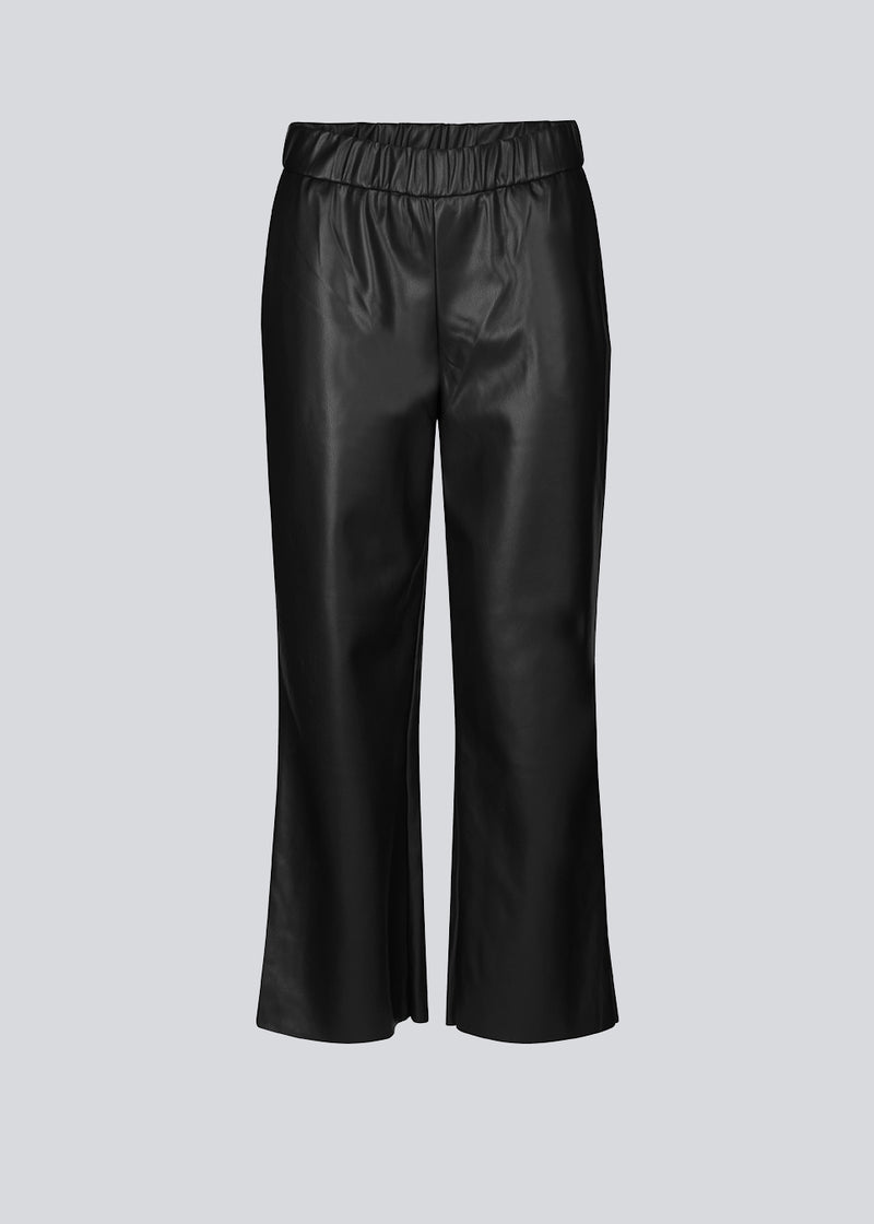 Ankellange bukser i sort med et afslappet fit i PU læder. AlmaMD pants har beklædt elastik i taljen og let svaj i benene.