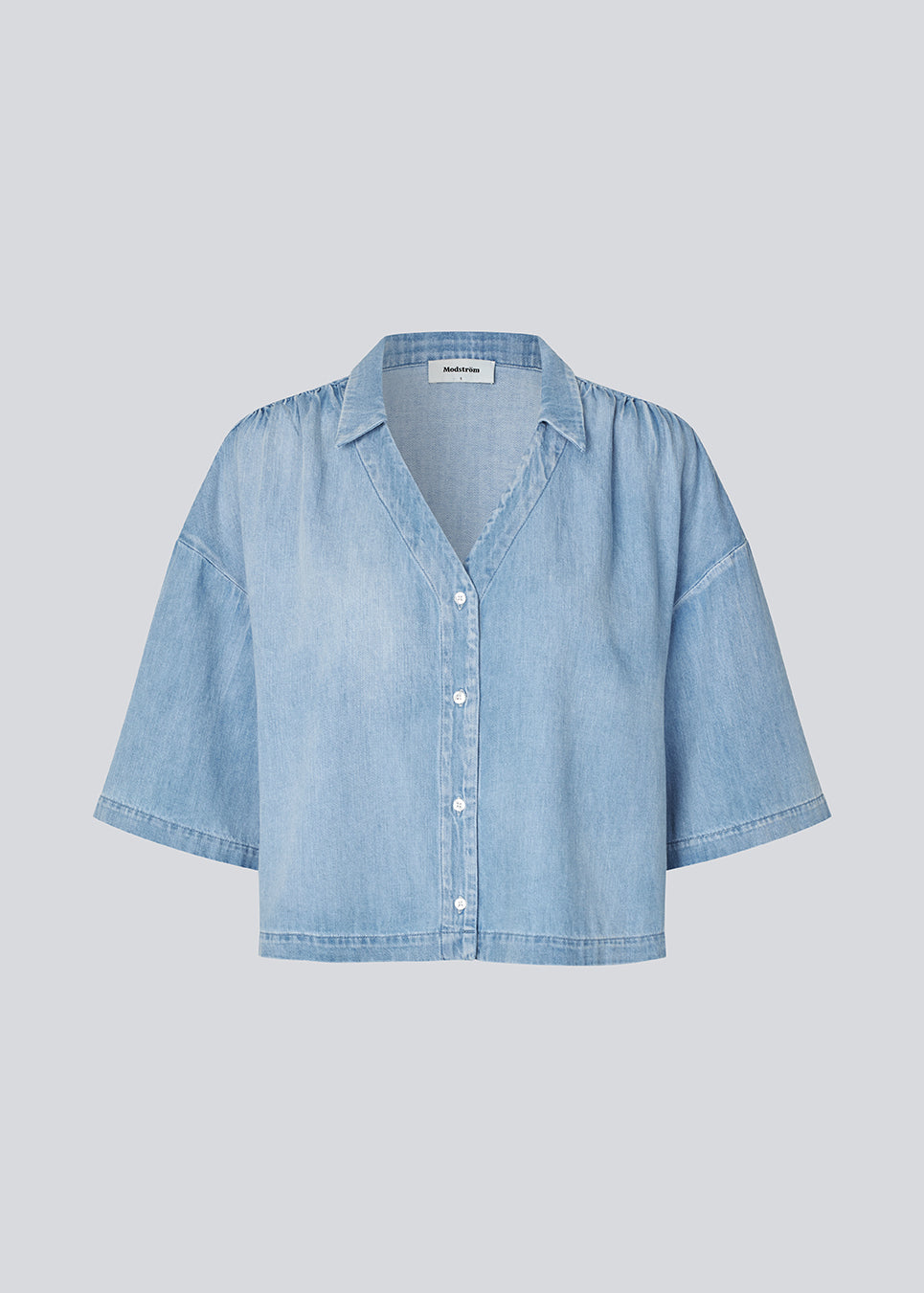Let kortærmet skjorte i bomuldsdenim. AlvarMD Shirt er kort og løs med krave, V-udskæring og knappelukning. En afslappet og moderne skjorte, perfekt til både hverdag og lette sommerlooks.