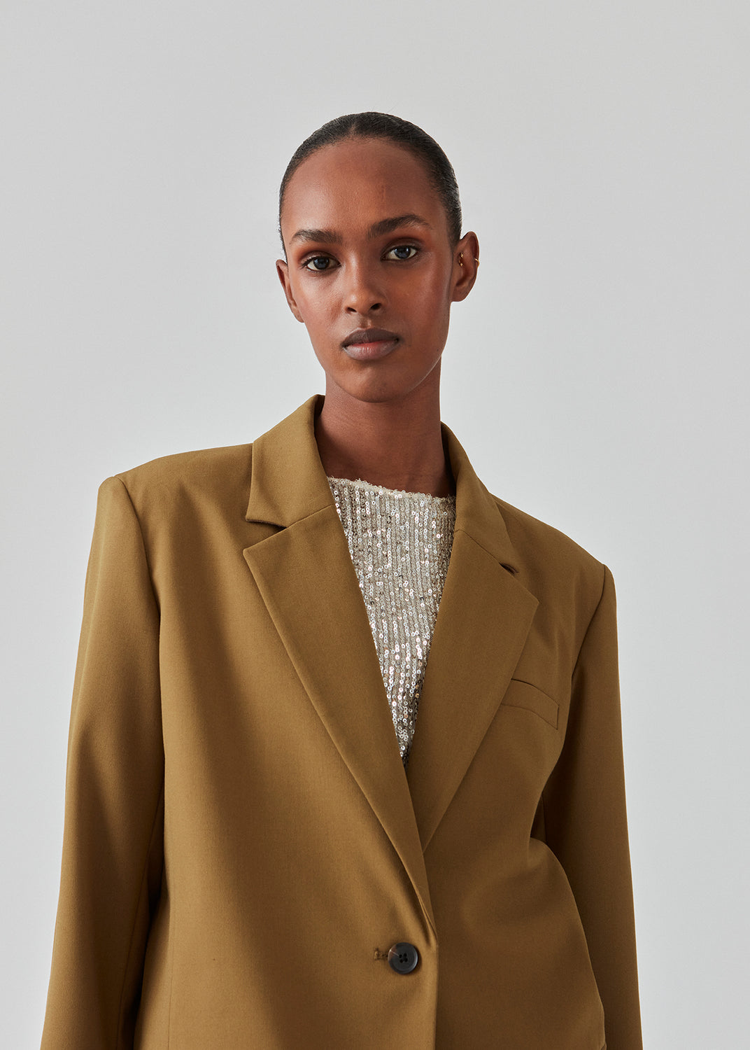 Oversized blazer i farven breen med blødt fald. AnkerMD blazer har krave og revers samt en knap foran. Forlommer med klap og brystlomme. Slids bagpå og ved ærmer. Med for.  Modellen er 177 cm og har en størrelse S/36 på. Style blazeren med matchende bukser i samme farve: AnkerMD pants.