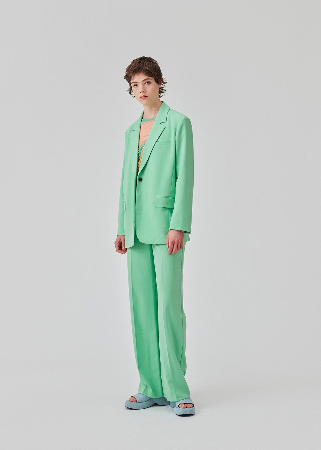 Oversized grøn blazer med blødt fald. AnkerMD blazer har krave og revers samt en knap foran. Forlommer med klap og brystlomme. Slids bagpå og ved ærmer. Med for. Modellen er 177 cm og har en størrelse S/36 på. Style blazeren med matchende bukser: AnkerMD pants, eller shorts: AnkerMD shorts, i samme farve.