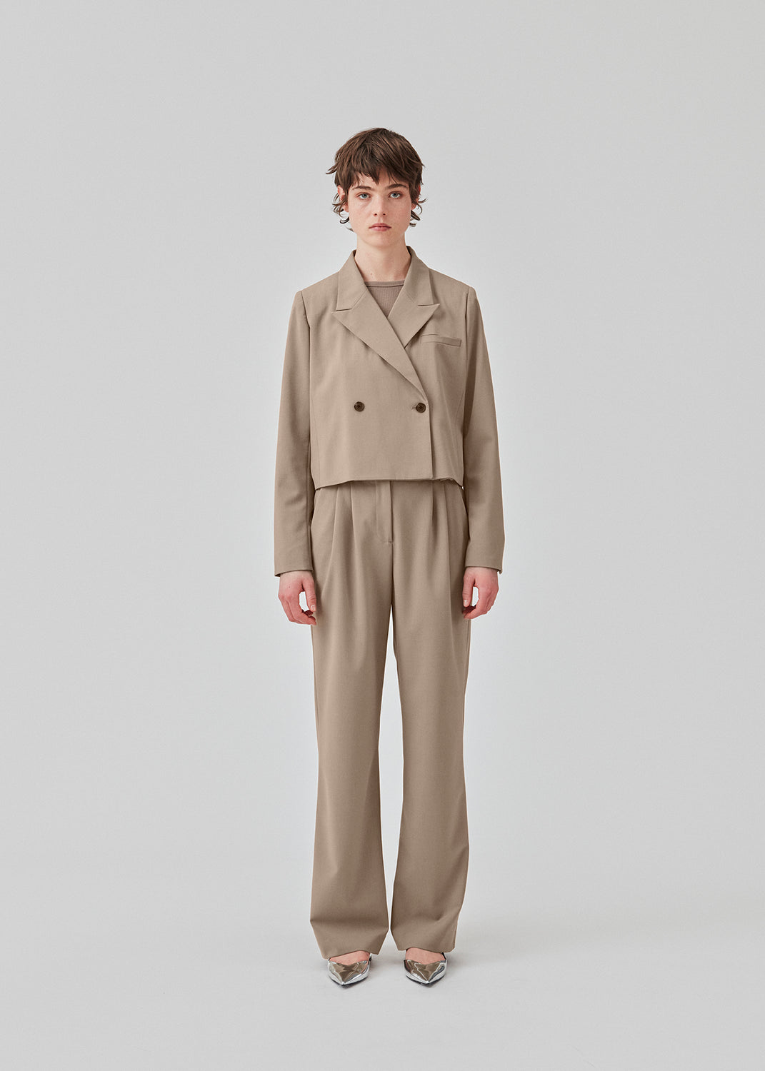 Kort, dobbeltraddet blazer med krave og spidsrevers i beige. AnkerMD short blazer har en lige pasform med to knapper og en dekorativ paspoleret brystlomme.