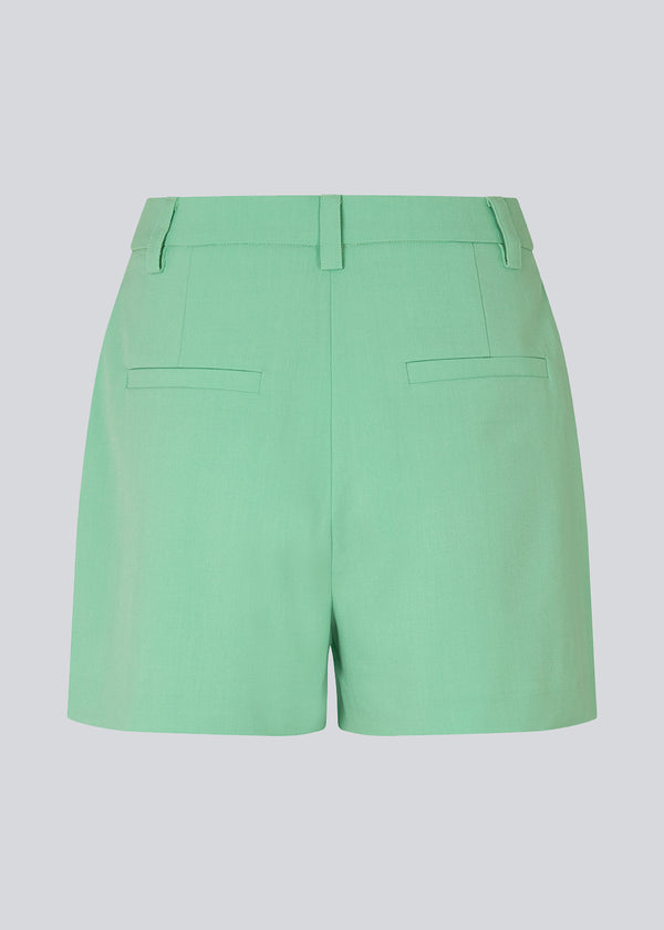 Shorts i grøn med brede ben og mellemhøj talje. AnkerMD shorts har pressefolder, gylp med lynlås og knap, skrå sidelommer og paspolerede baglommer. Style shorts med matchende blazer: AnkerMD blazer, i samme farve.