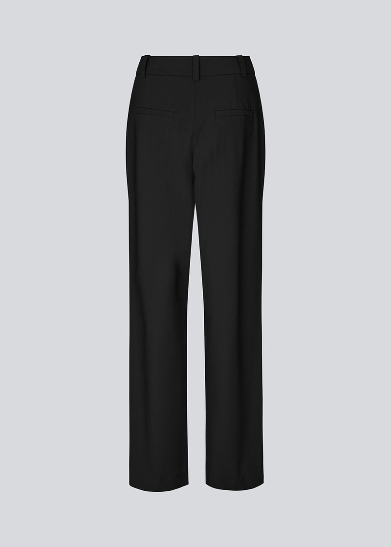 Bukser i sort med høj talje med læg og lange, vide ben. BennyMD pants har gylp med lynlås og knap, bæltestropper, diskrete sidelommer og dekorative paspolerede baglommer.