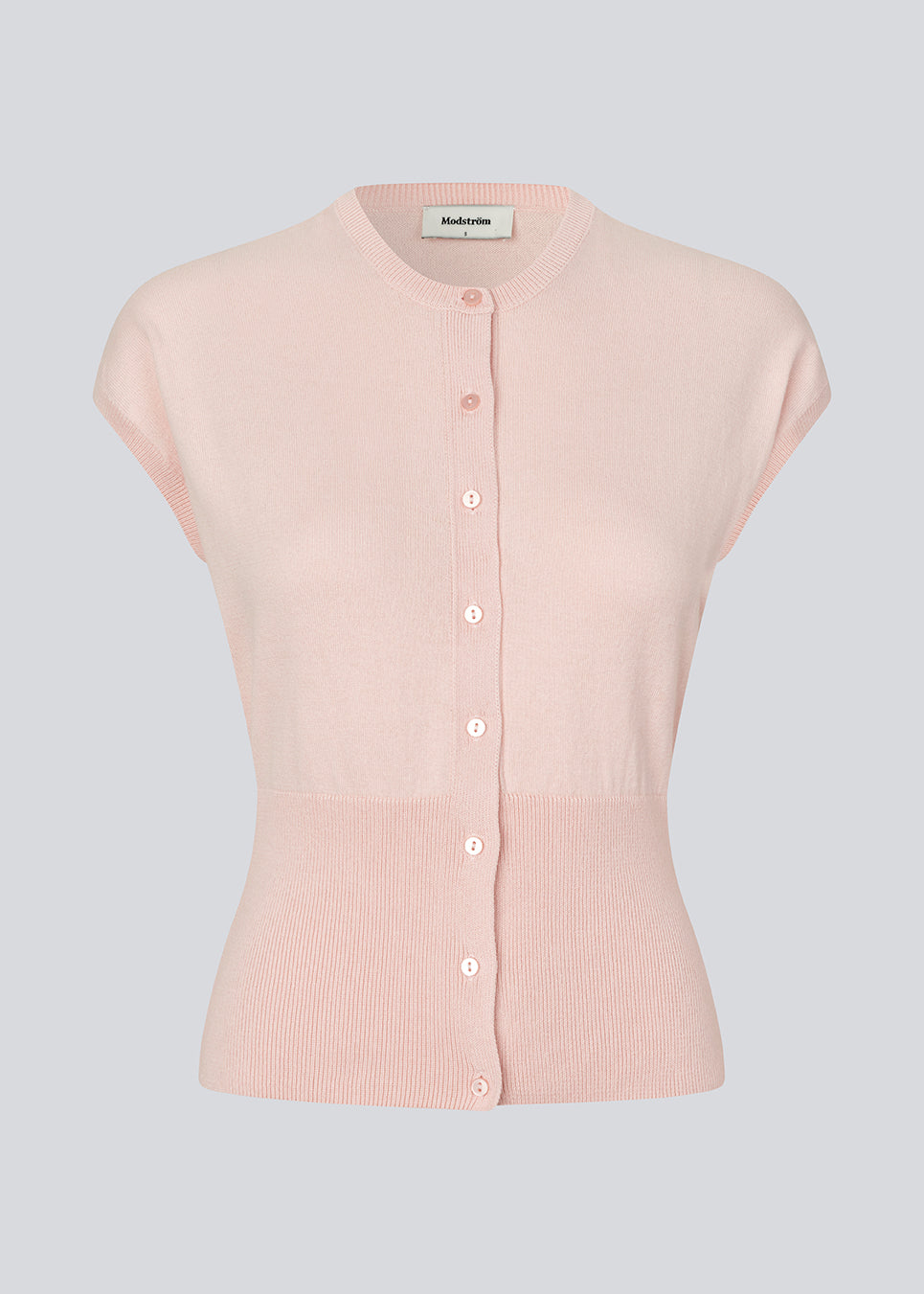 Feminin ærmeløs cardigan i let, luksuriøs strik. Bernadette MD Vest har elegante ribkanter, stilfuld knappelukning og rund halsudskæring, et figursyet snit med ekstra bred ribkant i taljen og er fremstillet i blød, 100% økologisk bomuld – et tidløst must-have til garderoben.