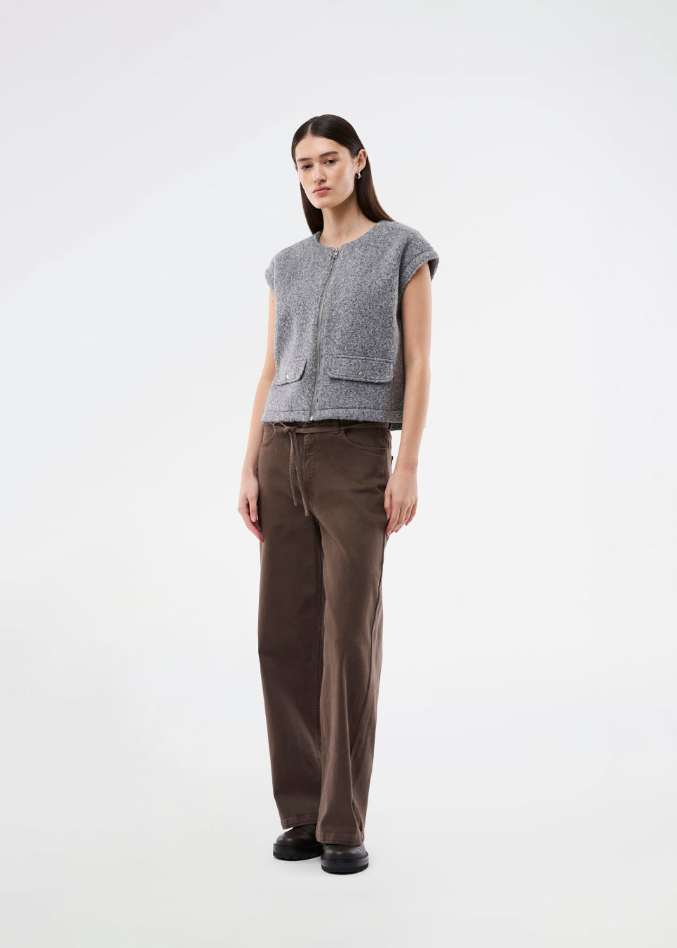 Trendy vest i uld-look. BibberMD Vest har lynlåslukning fortil, rund hals og sidelommer med lommeflapper og trykknapper – et stilrent og chic layering-piece, der giver et moderne og polished touch til garderoben.