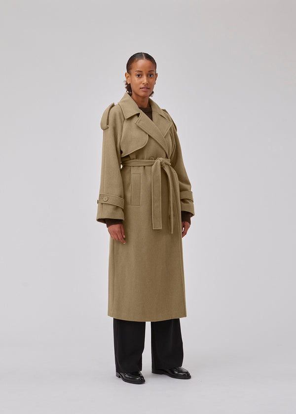 Frakke i Dune i trenchcoat-stil med oversized pasform. BorakMD coat er dobbeltradet med krave, stormflap, bindebælte i taljen og slids bagpå. Uldkvalitet med for.