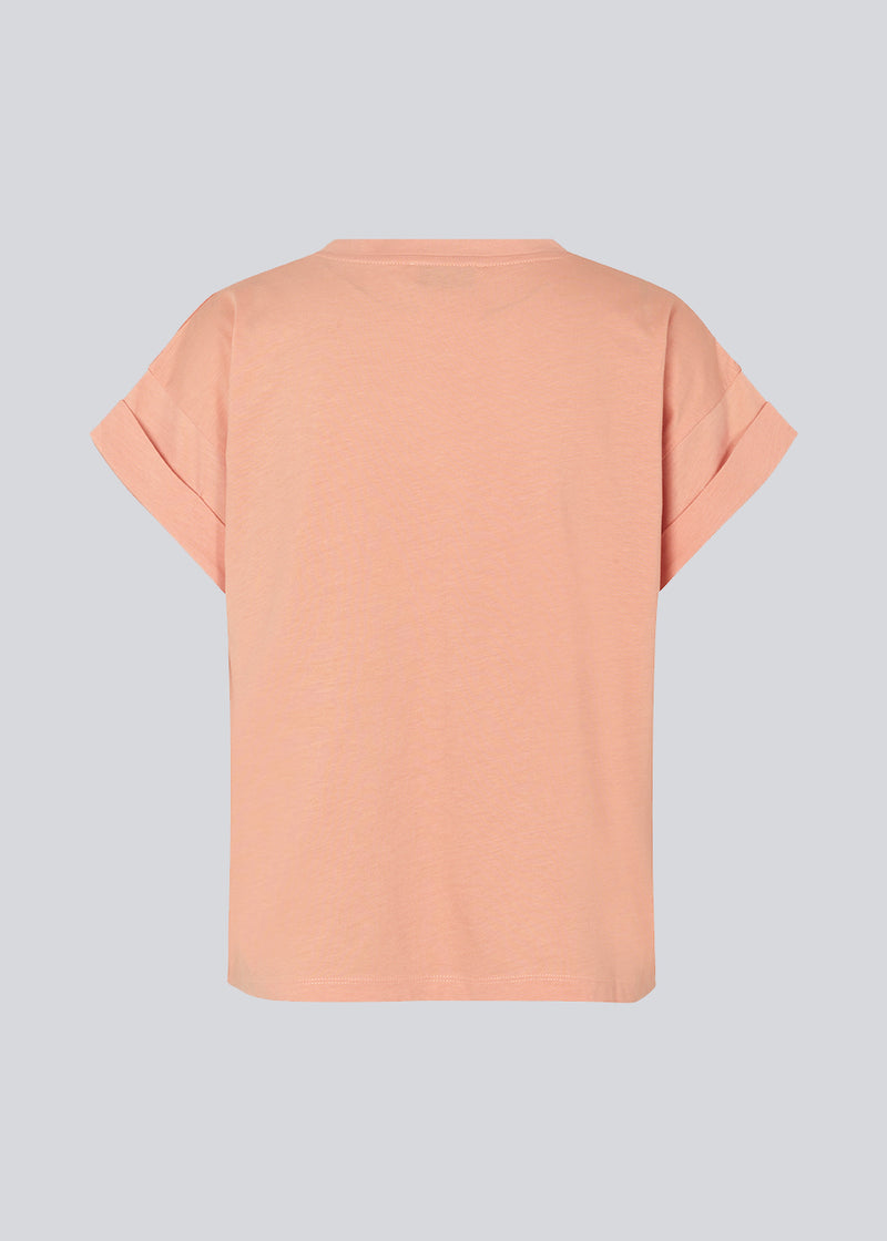 T-shirt i farven Peach Nectar i økologisk bomuld med en smule kortere længde. BrazilMD short t-shirt har rund hals og opsmøgede ærmer. Modellen er 177 cm og har en størrelse S/36 på.