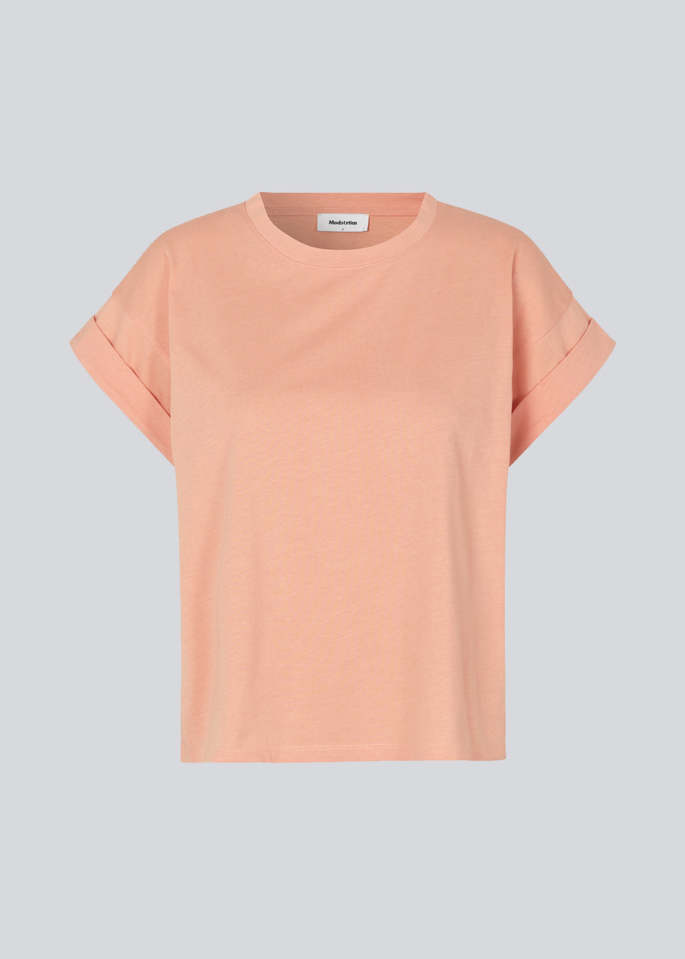 T-shirt i farven Peach Nectar i økologisk bomuld med en smule kortere længde. BrazilMD short t-shirt har rund hals og opsmøgede ærmer. Modellen er 177 cm og har en størrelse S/36 på.