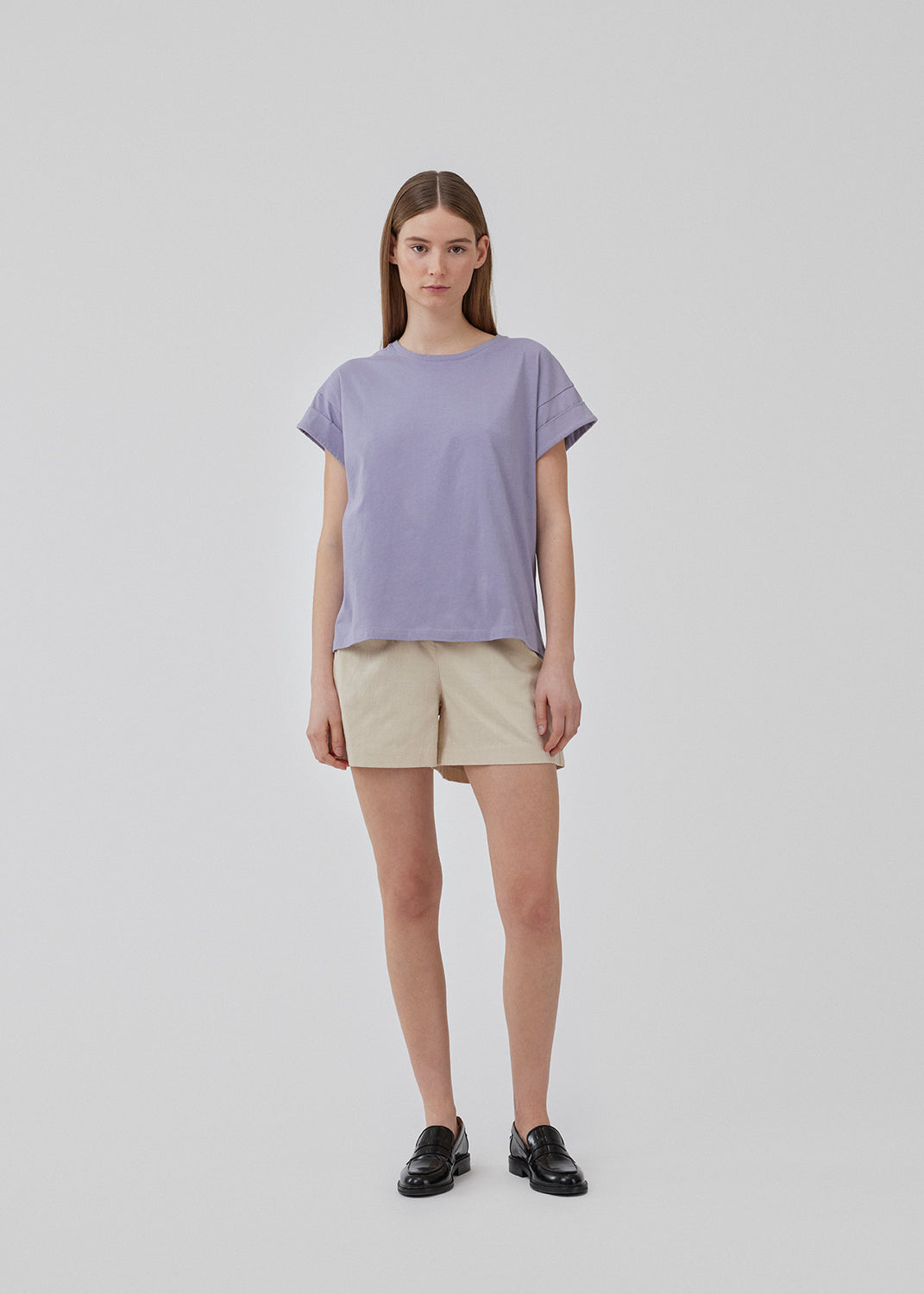 T-shirt i lilla i økologisk bomuld med en smule kortere længde. BrazilMD short t-shirt har rund hals og opsmøgede ærmer. Modellen er 177 cm og har en størrelse S/36 på.<br>