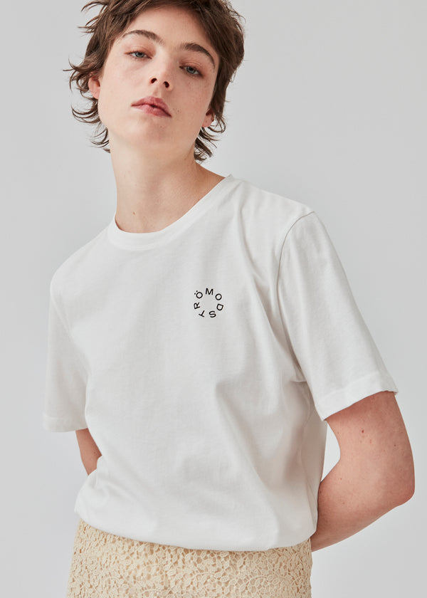 Hvid klassisk t-shirt i økologisk bomuld. CadakMD print t-shirt har en rund hals og korte ærmer, samt et printet logo foran. Modellen er 177 cm og har en størrelse S/36 på.