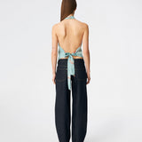 Elegant halterneck-top med et kunstnerisk print og et feminint udtryk. Carinamd print top er designet i en let, glat kvalitet med en høj halterneck-udskæring, der lukkes i nakken, og et bindebånd i ryggen, som giver en smuk og justerbar pasform. Det draperede design og det unikke print gør toppen til et iøjnefaldende valg til både festlige lejligheder og sommerens elegante outfits.