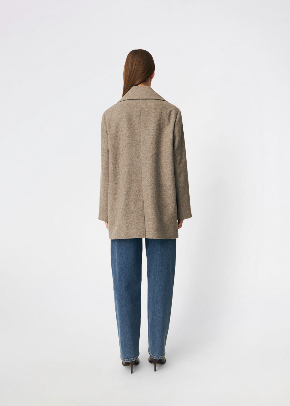 Cecarmd Jacket er en klassisk dobbeltradet jakke med en afslappet, oversized pasform. Designet er fuldendt med brede revers, klaplommer og en aftagelig blomsterbroche, som tilfører et feminint og dekorativt element. Den bløde uldblanding gør jakken ideel som overgangsjakke eller som et elegant lag over sæsonens strik og tailoring.