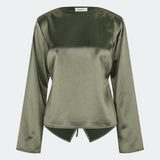 Elegant satinbluse med et feminint og moderne udtryk. Cianomd top er designet i en glansfuld satinkvalitet med lange ærmer, en bådudskæring og en dekorativ åben ryg med bindebånd, der tilfører et sofistikeret look. En stilfuld garderobefavorit, der passer perfekt til både skræddersyede bukser, jeans og festlige nederdele.