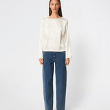 Elegant satinbluse med et feminint og moderne udtryk. Cianomd top er designet i en glansfuld satinkvalitet med lange ærmer, en bådudskæring og en dekorativ åben ryg med bindebånd, der tilfører et sofistikeret look. En stilfuld garderobefavorit, der passer perfekt til både skræddersyede bukser, jeans og festlige nederdele.