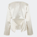 Elegant satinbluse med et feminint og moderne udtryk. Cianomd top er designet i en glansfuld satinkvalitet med lange ærmer, en bådudskæring og en dekorativ åben ryg med bindebånd, der tilfører et sofistikeret look. En stilfuld garderobefavorit, der passer perfekt til både skræddersyede bukser, jeans og festlige nederdele.