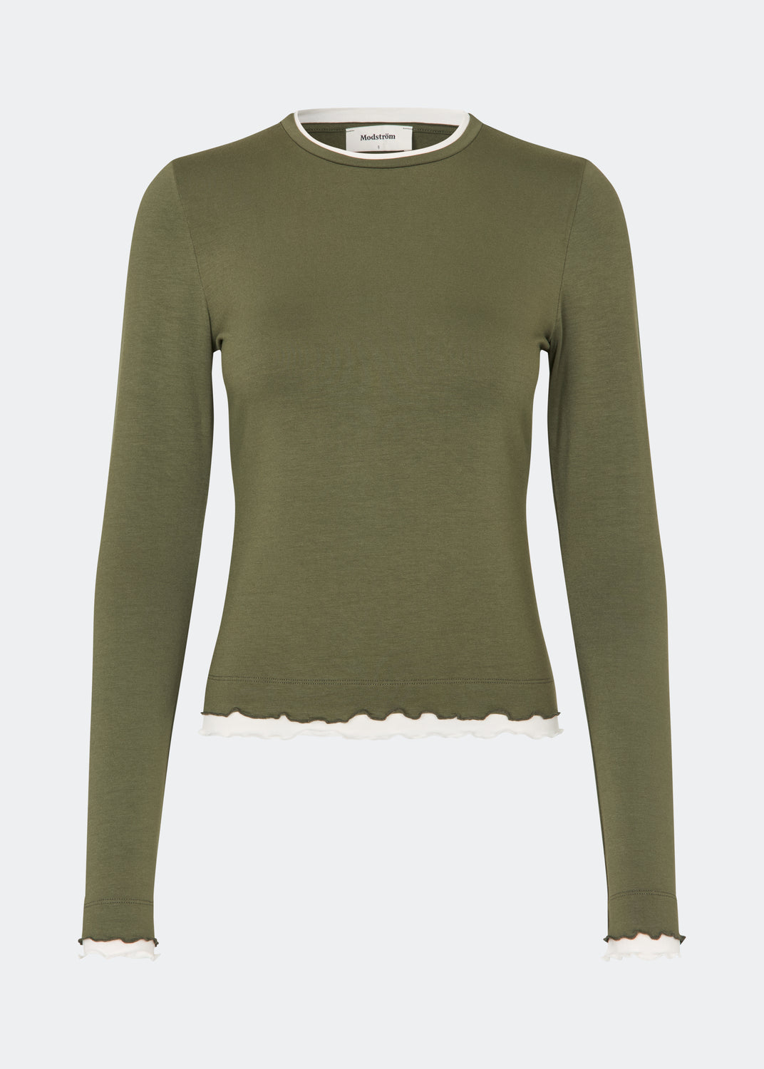 Langærmet T-shirt i en blød og komfortabel kvalitet. CiljaMD LS T-shirt har en tætsiddende silhuet med rund halsudskæring og dekorative kontrastkanter ved hals, manchetter og forneden, som skaber en lag-på-lag-effekt. De bølgede afslutninger tilfører et feminint touch til det enkle design, hvilket gør den perfekt både alene og som et lag under strik, skjorter eller jakker.